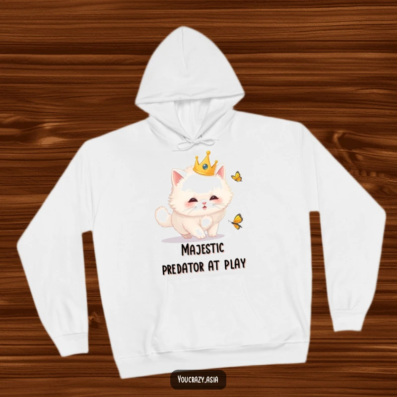 Funny cat hoodie depicting a fluffy white cat wearing a golden crown, hilariously pursuing a butterfly in a cozy, whimsical scene.