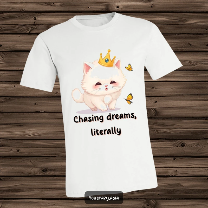 Funny cat t-shirt featuring a fluffy white cat in a golden crown, enthusiastically chasing a butterfly, exuding regal silliness and joy.